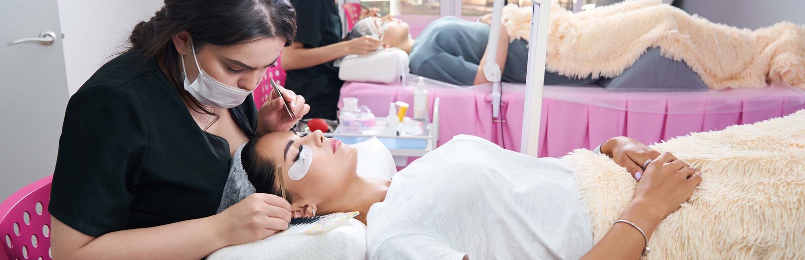 Process of eyelash extensions in the beauty studio. Professionals and clients